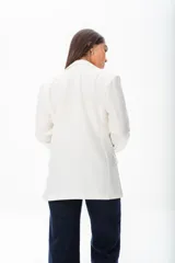 Blazer blanco de poliéster, viscosa y spandex, de corte recto, con botones a tono, manga larga y cierre frontal.