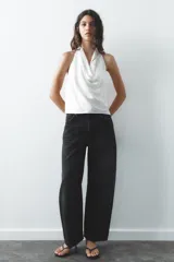 Top negro de satén con cuello halter drapeado ajustable con lazada en el cuello y espalda descubierta con lazada.