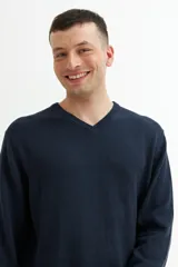 Sweater gris de punto con escote en V y mangas largas.