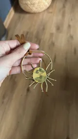 Gargantilla con tira de cuero sintético marrón y dije dorado con forma de sol.