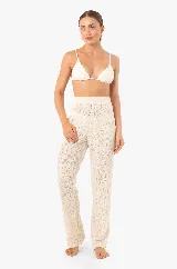 Pantalón de punto color crudo con diseño de encaje, corte recto, con bolsillos y cintura elástica.