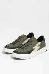 Zapatillas deportivas color verde militar con detalles en negro y beige. Presentan cordones negros, suela blanca y un rayo beige en el lateral.