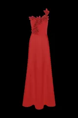 Vestido largo color rojo, confeccionado en tela fluida de crepe. Presenta un escote asimétrico con una sola tira decorada con aplicaciones florales artesanales en relieve del mismo tono. La silueta es larga y estilizada.