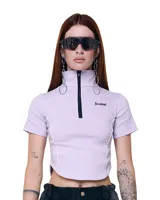 Top cropped lila de gabardina elastizada, con cuello alto, cierre frontal, silueta entallada y costuras a contratono.