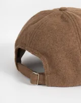 Gorra de béisbol color beige con visera marrón, bordado frontal con la inscripción "Wednesday 1996" y regulador metálico trasero.