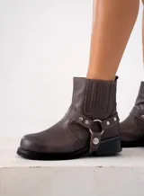 Bota corta negra de cuero vacuno con estribo desmontable, suela de caucho, cierre interno y punta redonda.