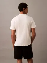 Remera de algodón color beige, de corte regular, cuello redondo y manga corta. Estampado frontal con logo de Calvin Klein en color negro.