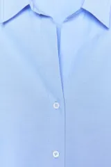 Camisa celeste de corte clásico, cuello solapa, escote en pico y manga larga.