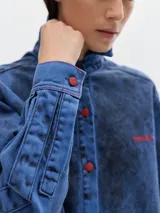 Camisa de jean oversized con lavado estilo washed, botones y bordado a contratono.