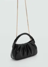 Bolso de mano negro con diseño acolchado, forro interior y doble asa corta.
