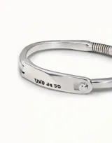 Pulsera rígida bañada en plata, con diseño minimalista y cierre de boina, confeccionada a mano.