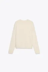 Chaqueta color crema de cuello redondo y manga larga, con bolsillos de parche con solapa en el frente y cierre frontal con corchete oculto.