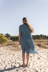 Vestido celeste de lino con mangas cortas y falda midi con volados de seda.