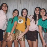 Remera verde de algodón manga corta con aplique de alas doradas en el pecho.