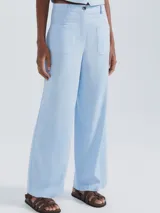 Pantalón de tiro alto, color celeste claro, de corte recto y pierna ancha. Presenta bolsillos parche grandes y cuadrados en la parte delantera.