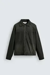 Sobrecamisa de denim de algodón negro con efecto lavado, corte relajado (relaxed fit). Presenta cuello solapa, cierre frontal con cremallera, manga larga con puño abotonado y bolsillo plastrón en el pecho.