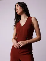 Mono enterito color ladrillo, marca June & Hudson, de crepe con escote en V, sin mangas, con detalle de botones en la cintura y cierre invisible en la espalda.