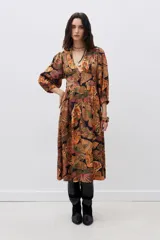 Vestido midi con estampado de mariposas en tonos naranja, verde y negro. Tiene escote en V, mangas largas abullonadas y abertura lateral en la falda.