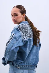 Campera de jean celeste con estampado animal print en cuello y solapas, y tres tiras blancas en las mangas.