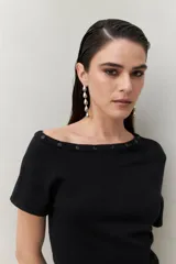 Top tejido azul marino de silueta ajustada con diseño minimalista y escote asimétrico, adornado con pequeños botones metálicos.