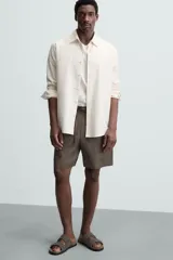 Bermuda negra de lino con calce relajado. Presenta cintura elástica ajustable con cordón, bolsillos frontales y un bolsillo trasero de plastrón.