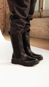 Bota de caña alta negra, con capellada de cuero y suela de TR, ideal para uso diario.