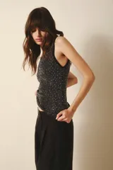 Musculosa negra con cuello halter y apliques de strass plateados.