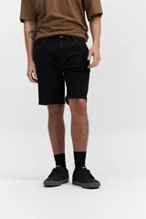 Bermuda de jean negra con dobladillo y corte a la rodilla.