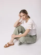 Remera blanca de poliéster y spandex con mangas cortas con volados de encaje.