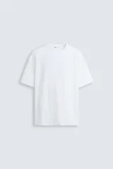 Remera blanca de corte holgado, cuello redondo y mangas cortas.