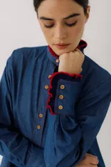 Camisa de jean azul con cuello mao, mangas largas y bolsillo de crochet en el pecho.