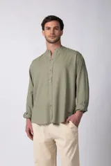 Camisa de manga larga color verde oliva, confeccionada en lino, con cuello mao y cierre frontal con botones.