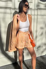 Short de lino a cuadros color naranja y blanco, estilo sastrero con calce holgado.