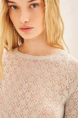 Remera negra de tejido calado con lurex, corte ajustado y mangas largas.