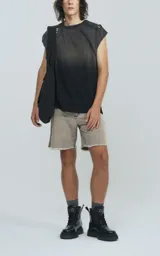 Remera negra sin mangas con efecto degradado y roturas en los hombros, de corte oversize.