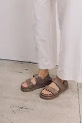 Sandalias bajas de cuero con plataforma, base color suela, plantilla azul y tiras de cuero en color beige, blanco y azul.