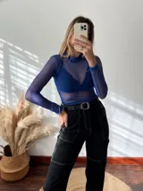 Remera de tul azul, con cuello redondo y mangas largas, en diseño ajustado.