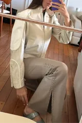 Pantalón Oxford de cuero ovino color visón con pasamanería a tono en los tajos laterales.