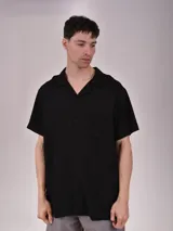 Camisa negra de manga corta con cuello solapa y bolsillo en el pecho.