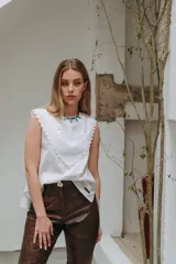 Musculosa blanca sin mangas con cuello babero de encaje.