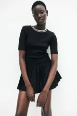 Remera negra de punto con cuello redondo y mangas cortas.