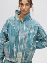 Campera rompevientos estilo biker con capucha desmontable, color celeste con estampado de nubes blancas y detalles en blanco.