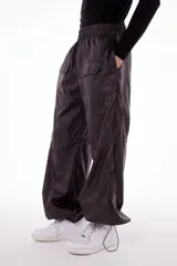 Pantalón wide leg impermeable negro con estampado de logos. Tiene bolsillos laterales ocultos, bolsillos en piernas y en posterior. Tiene tanca en ruedo para ajustar.