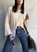 Sweater beige de punto calado con mangas acampanadas.