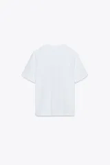 Camiseta blanca de algodón con cuello redondo y mangas cortas. Estampado frontal con la frase "Paris, Mon doux rêve!" en azul marino.