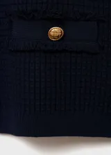 Chaqueta azul marino de punto con cuello redondo, cierre frontal con botones dorados, dos bolsillos delanteros y manga larga.