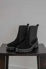 Bota negra de gamuza y neopreno, con suela gruesa y diseño moderno.