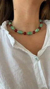 Collar corto con cuentas de piedra verde, cuentas de piedra roja y detalles dorados.