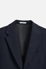 Blazer slim fit azul marino confeccionada en tejido con 17% de lana. Cuello con solapas de muesca, manga larga acabada en puño con detalle de botones, bolsillo de vivo en pecho y de solapa en cadera, detalle bolsillo interior, bajo con aberturas en espalda y cierre frontal con botones.