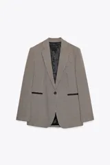 Blazer de cuello solapa y manga larga con estampado de pata de gallo en tonos marrones y negros. Bolsillos de vivo en delantero, detalle de coderas a contraste y cierre frontal con botón.
